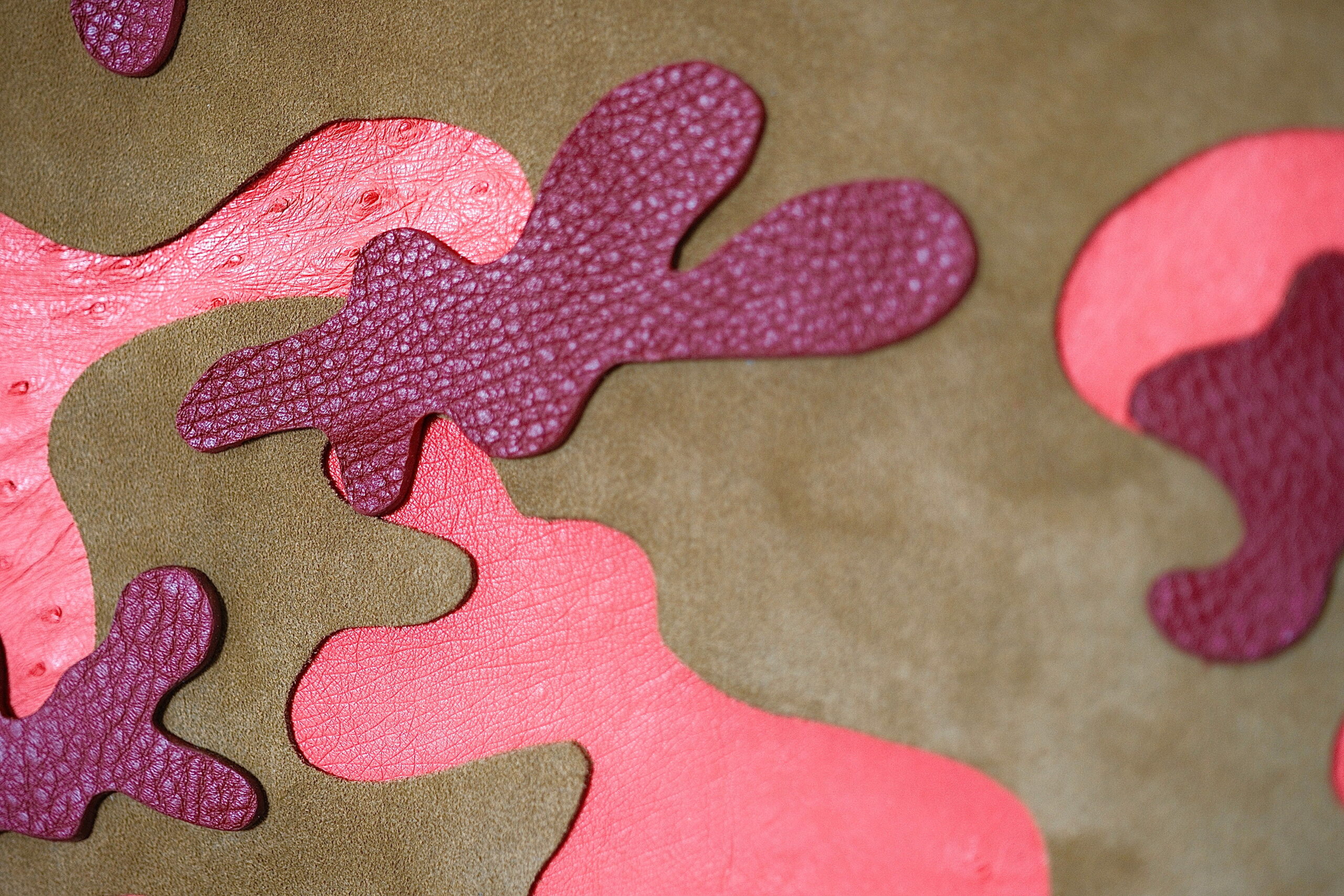 Détail des formes en cuir rose, rouge et violet