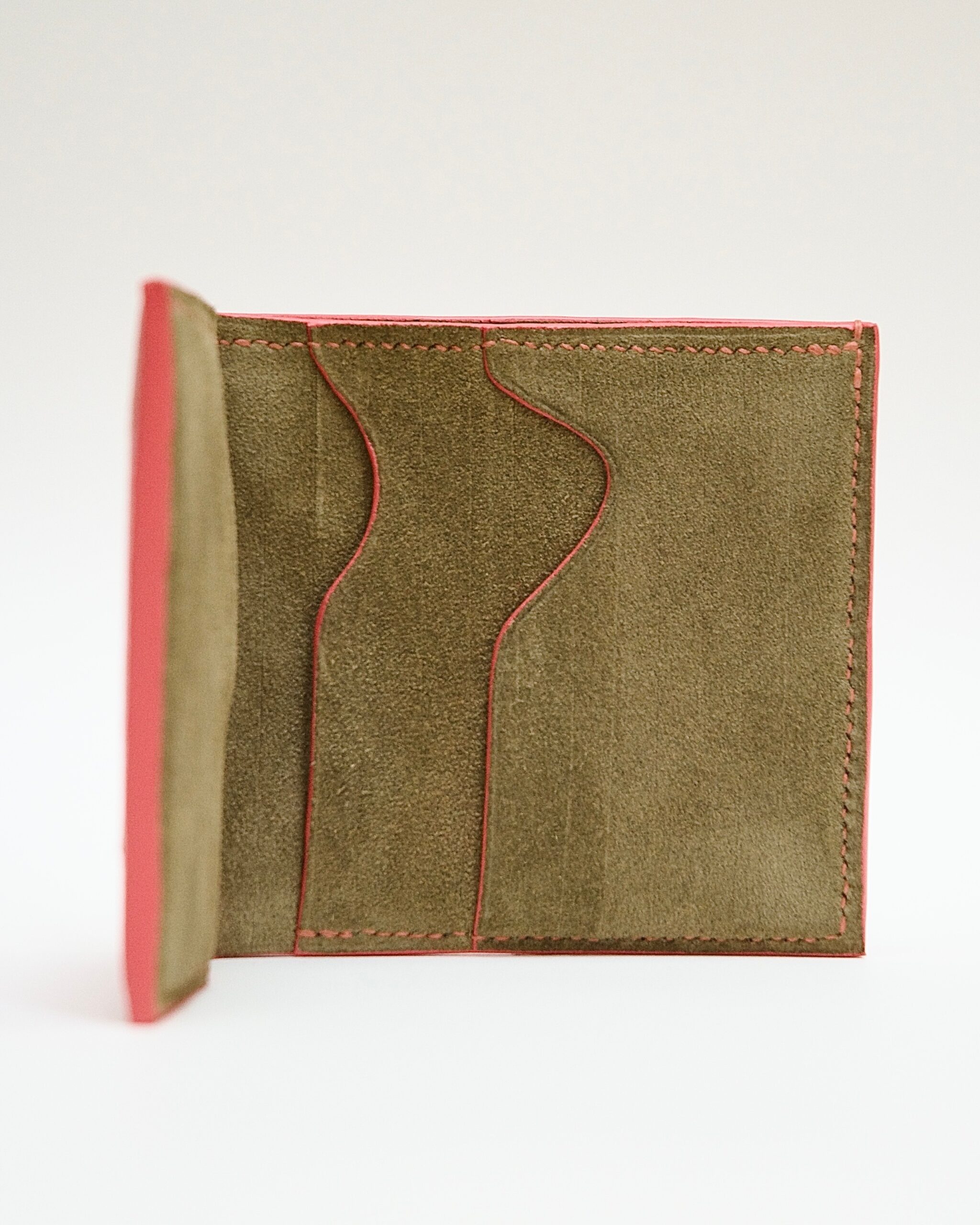 Intérieur du portefeuille Empreinte Manumissio en nubuck mousse, avec compartiments pour cartes et finitions corail.